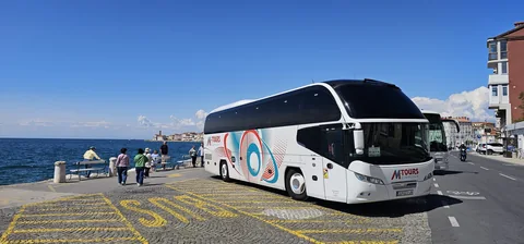 Touring coach parked by a waterfront promenade