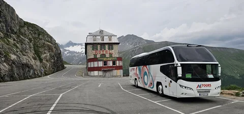 Coach parked beside a mountain road and rocky landscape