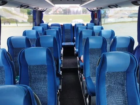Blue passenger seats viewed towards the front of the coach