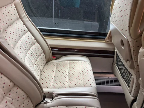 Beige passenger seat beside the coach window